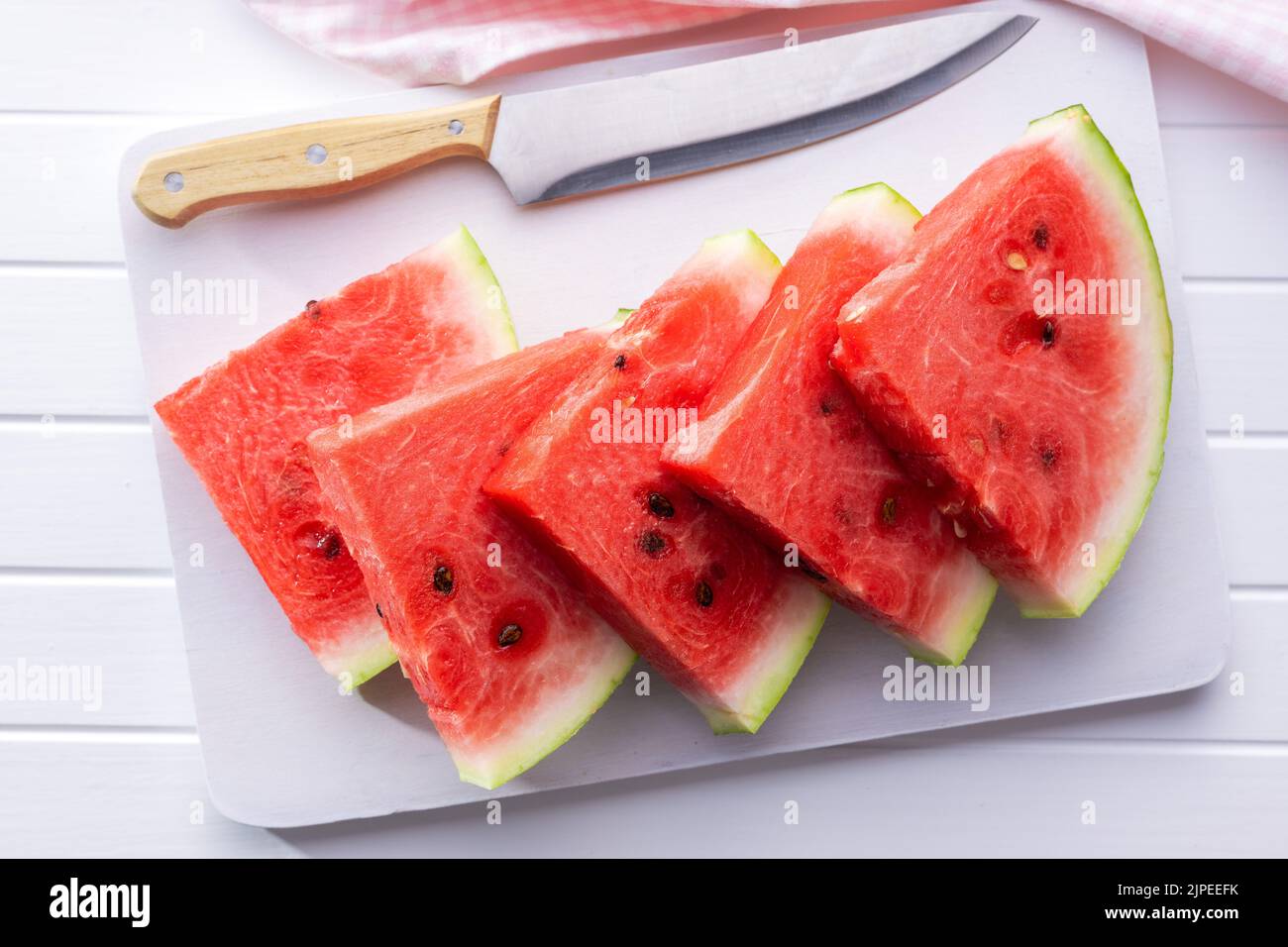 Slices of red watermelon on a cutting board. Top view. Stock Photo