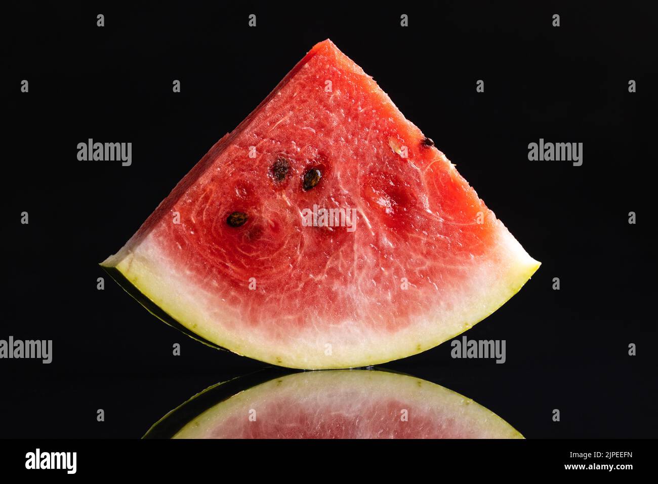 Slices of red watermelon on a black background. Stock Photo