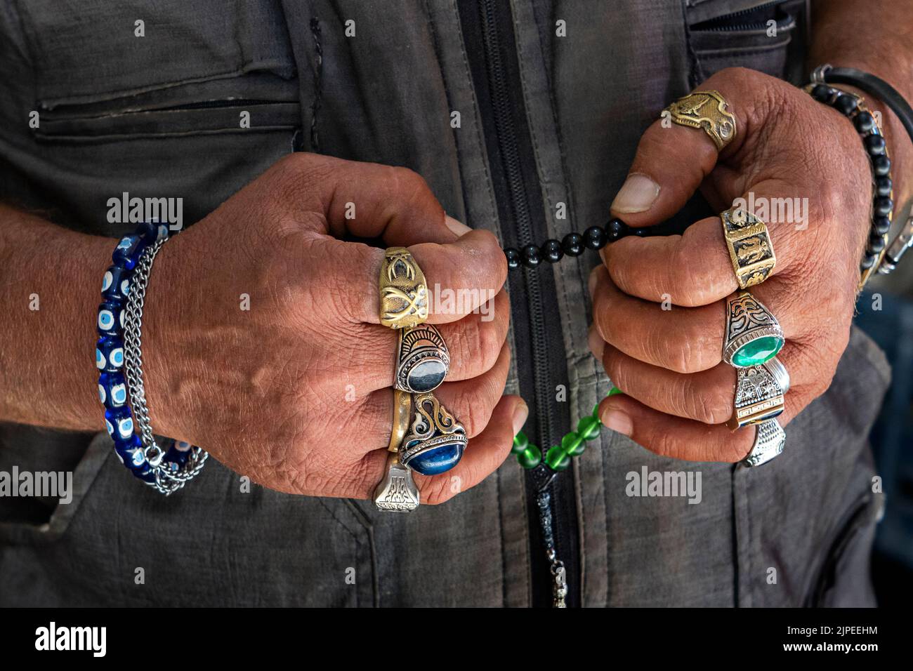 Hands wearing rings and holding worry beads, Turkey Stock Photo