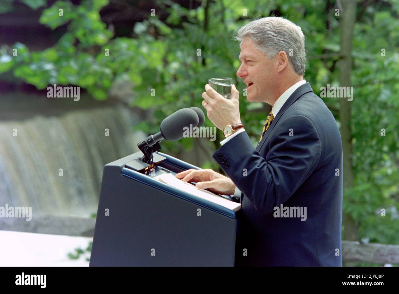 U.S. President Bill Clinton holds up a glass of drinking water as he