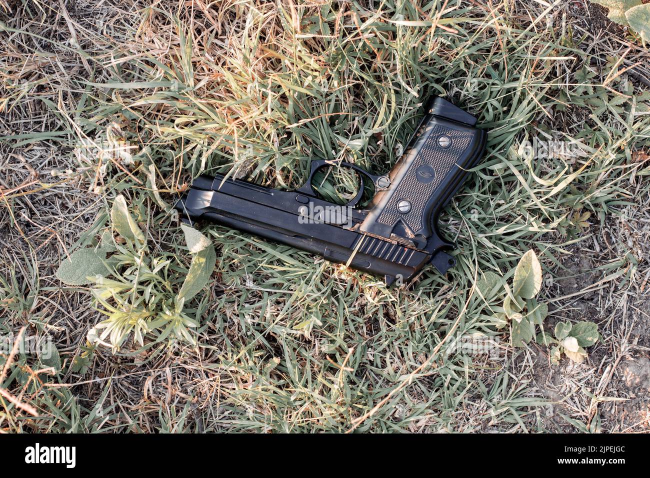 The black pistol is on the ground. Firearms on the street. Stock Photo