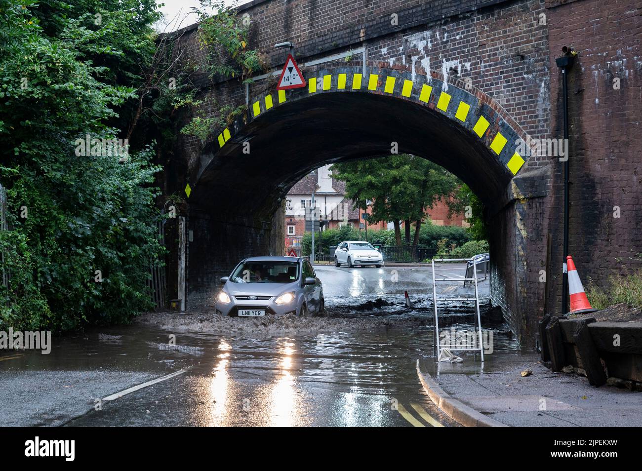 Haslemere, UK, Wednesday, 17th August 2022. A car drives under a railway bridge through a large flood after torrential rainfall brings the summer heatwave to an end, Weyhill, Haslemere, Surrey.  Credit: DavidJensen / Empics Entertainment / Alamy Live News Stock Photo