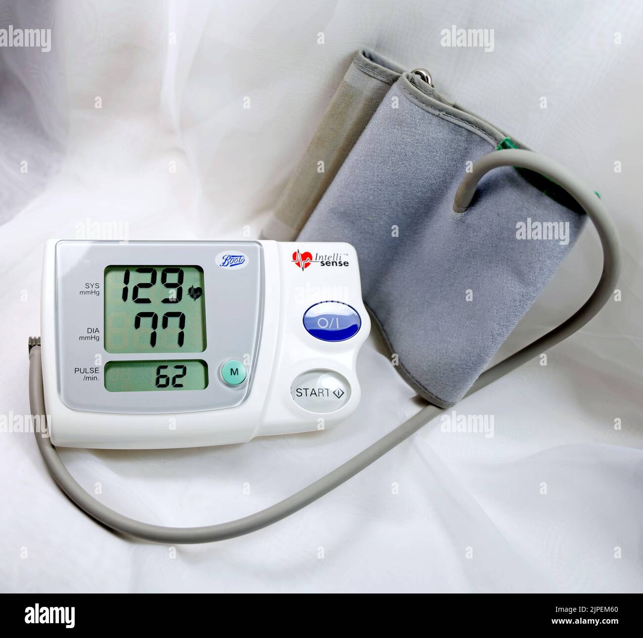 Blood pressure monitor and cuff showing blood pressure reading and pulse rate. Stock Photo