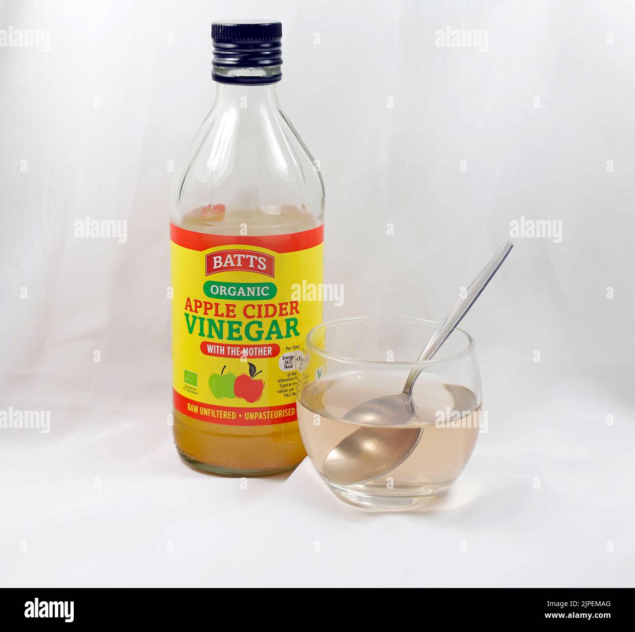 Organic apple cider vinegar with mother - clear bottle with small glass and teaspoon. Stock Photo