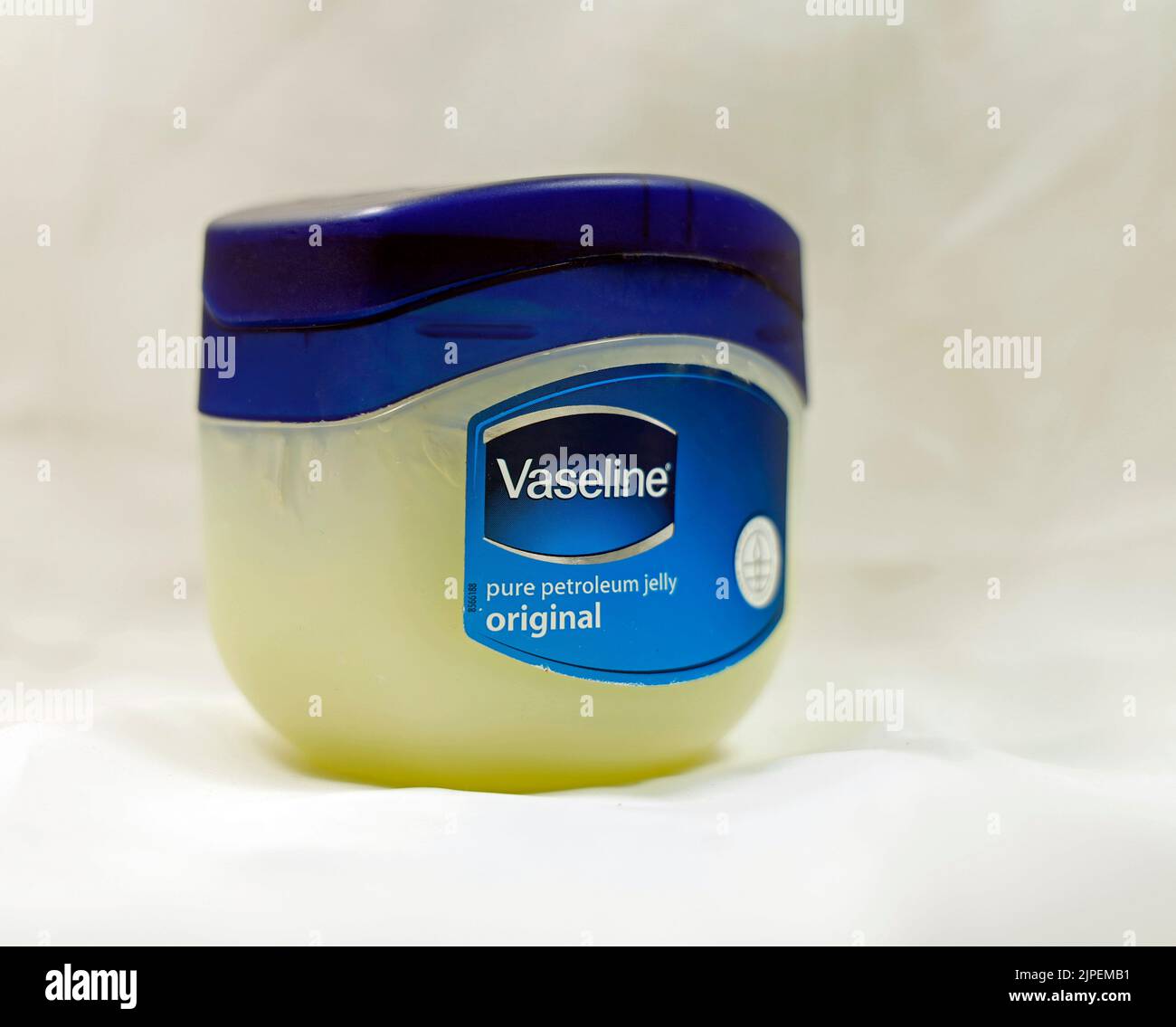 Vaseline petroleum jelly. Plastic tub / container with blue lid against white/grey background Stock Photo