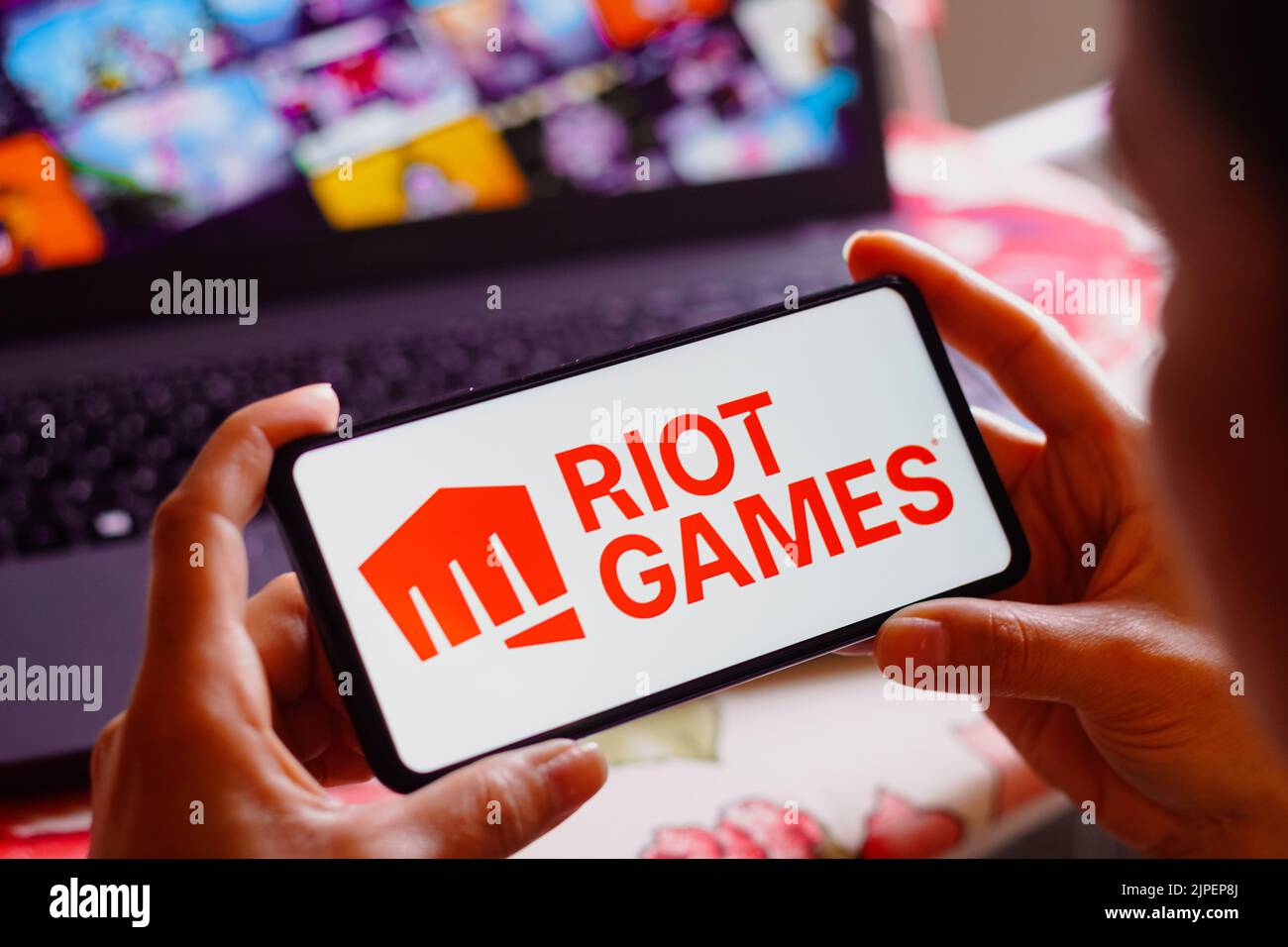 In this photo illustration, the Riot Games logo is displayed on a smartphone screen. Stock Photo