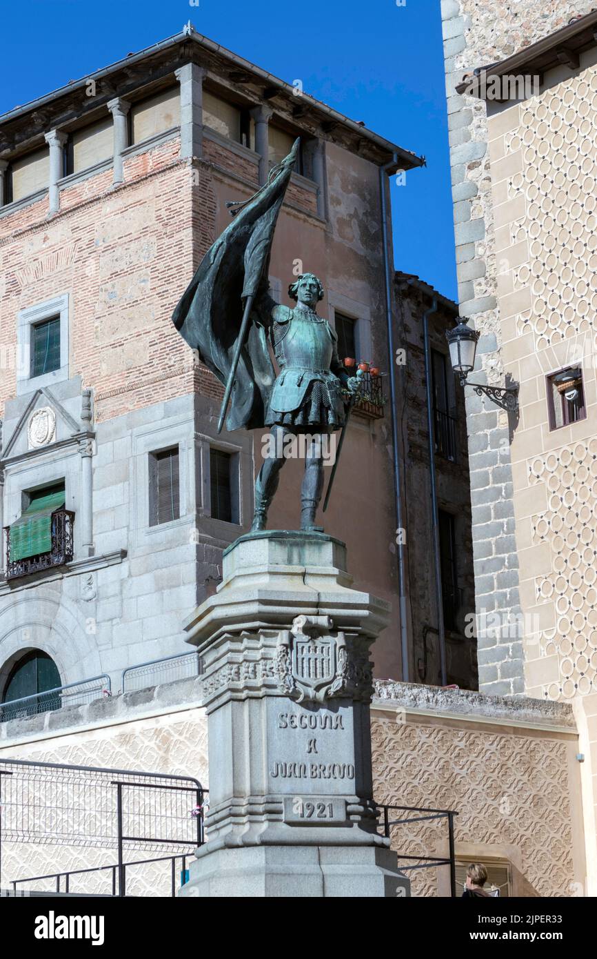 The statue of Juan Bravo in Segovia with a flag in his hand and residential buildings in the background,vertical shot Stock Photo