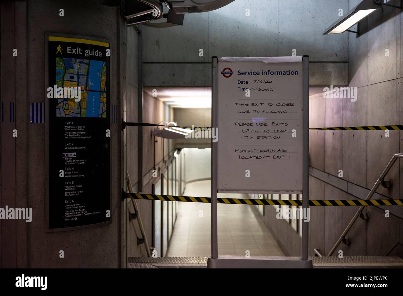 Noticeboard has been put up on a blocked exit at Westminster Underground Station after flooding due to torrential rain. Several underground stations are flooded this afternoon after the torrential rain lashed London. Rainwater struggles to permeate dry ground through the dehydrated surface and lead to flash flooding after torrential rain. Stock Photo