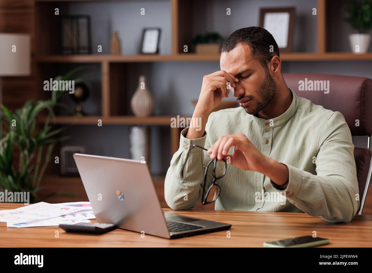 Tired african american businessman after exhausting paperwork taking