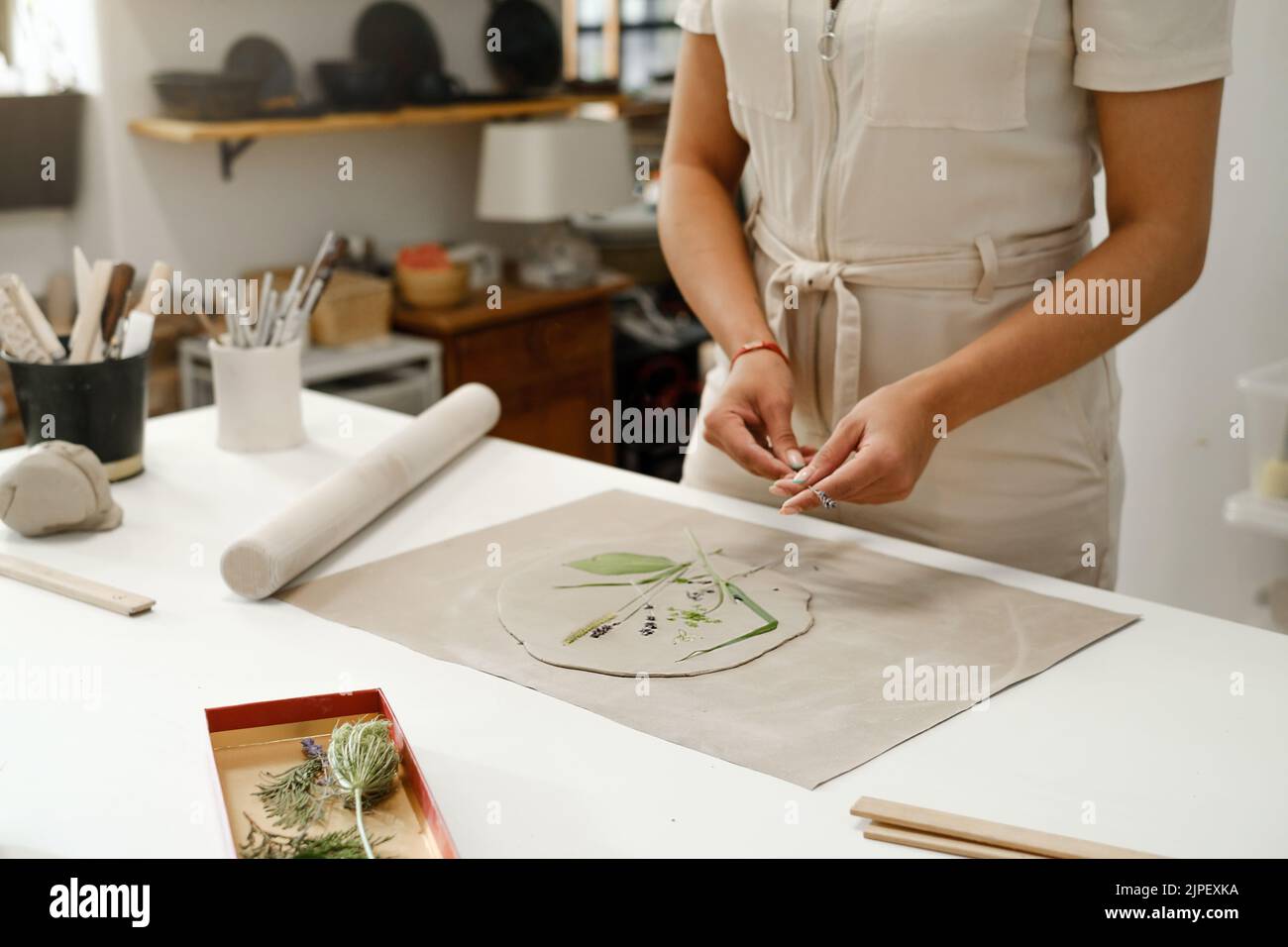 Pottery in studio. Person working with clay by the table