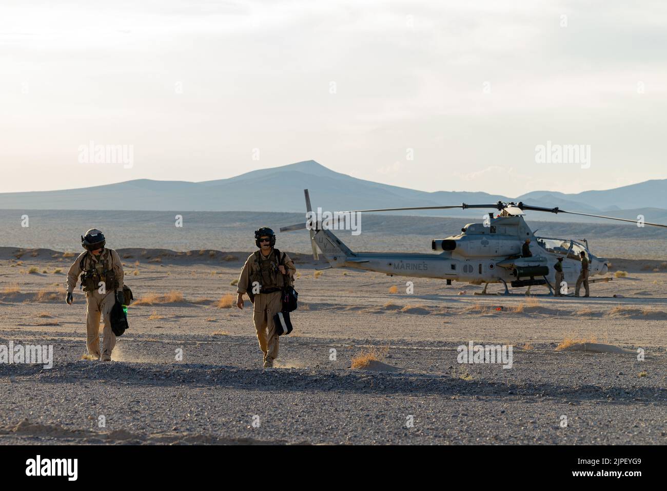 U.S. Marine Corps AH-1W Cobra pilots with Marine Light Attack Helicopter Squadron 267 (HMLA-267), Marine Aircraft Group 39, 3rd Marine Aircraft Group, finish flying for the day during Summer Fury 22 at Fort Irwin, California,  August 03, 2022. By operating out of forward aviation nodes, HMLA-267 demonstrated expeditionary capabilities in an austere environment. Summer Fury 22 is designed to enhance Marine-Air-Ground Task Force integration and increase aviation operations proficiency with realistic, relevant training to ensure the Marine Corps’ largest aircraft wing remains operationally excell Stock Photo