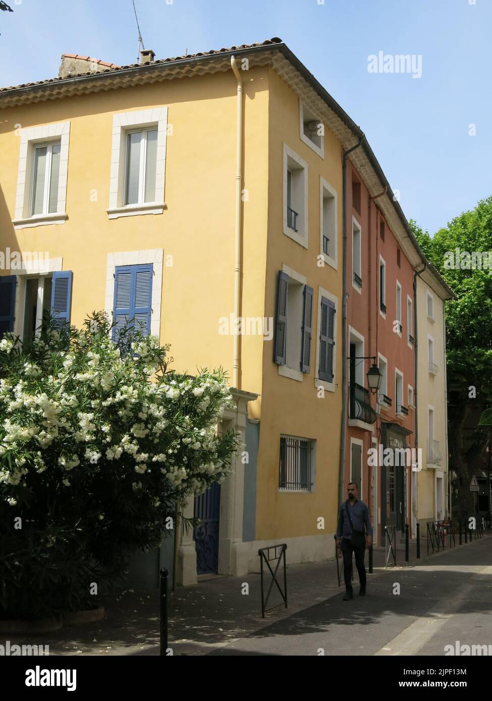 Brightly coloured buildings and tall town houses in the French historic city of Orange. Stock Photo