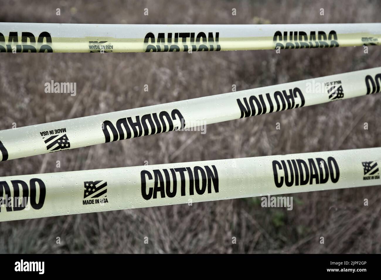 'Caution - Cuidado'  plastic tape, english & spanish language, restricted entry,  notification, plastic tape, made in USA, Stock Photo