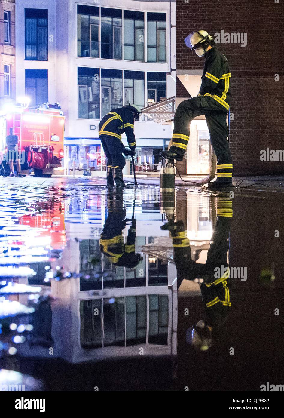 Hamburg, Germany. 17th Aug, 2022. Firefighters pump water from a street ...
