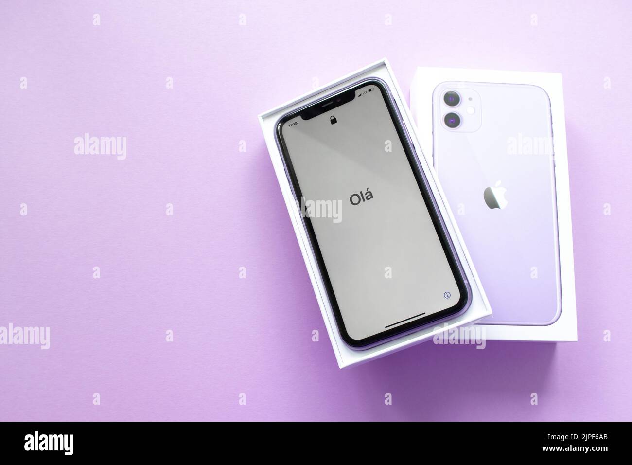 Moscow, Russia, May 2021: A new iPhone 12 model of violet color in an open branded box on a lilac background. On the iPhone screen, a welcome in in Po Stock Photo