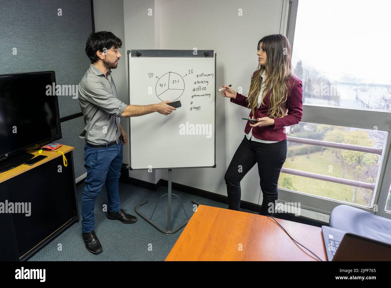 Employees making a presentation to their office colleagues in the meeting room Stock Photo