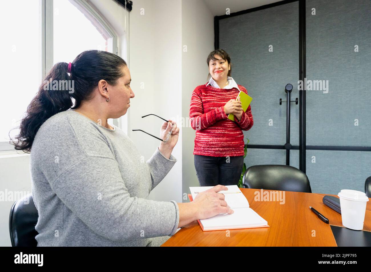 Businesswoman sitting at the head of the meeting table looking at her