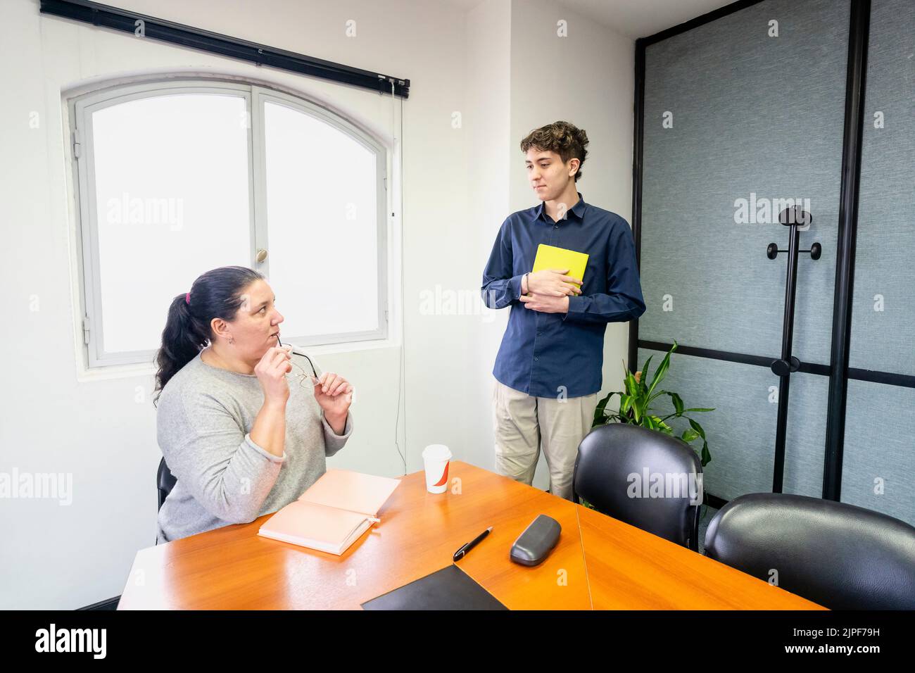 Businesswoman sitting at the head of the meeting table looking at her