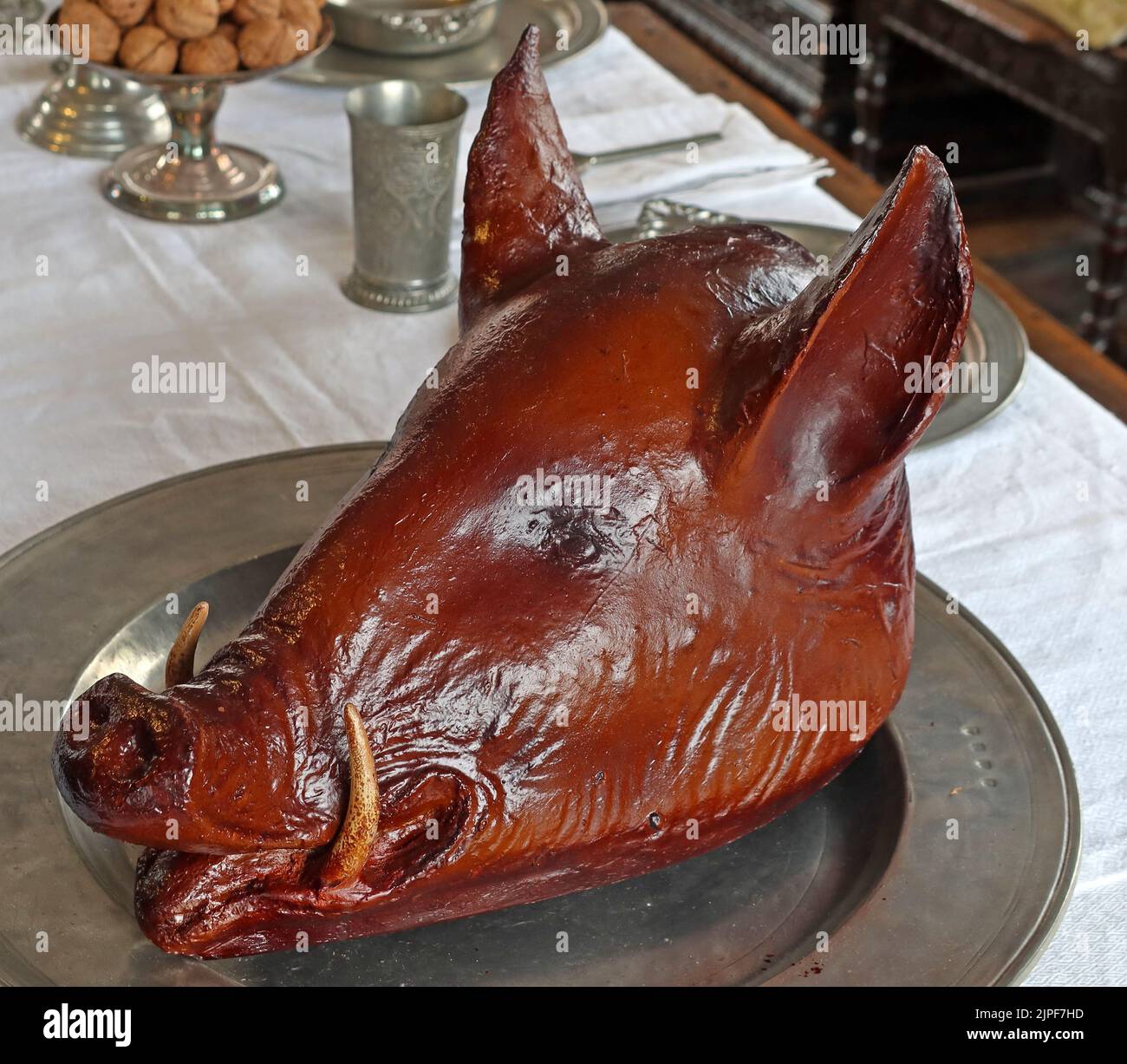 A cooked roasted pigs head, on a pewter plate Stock Photo