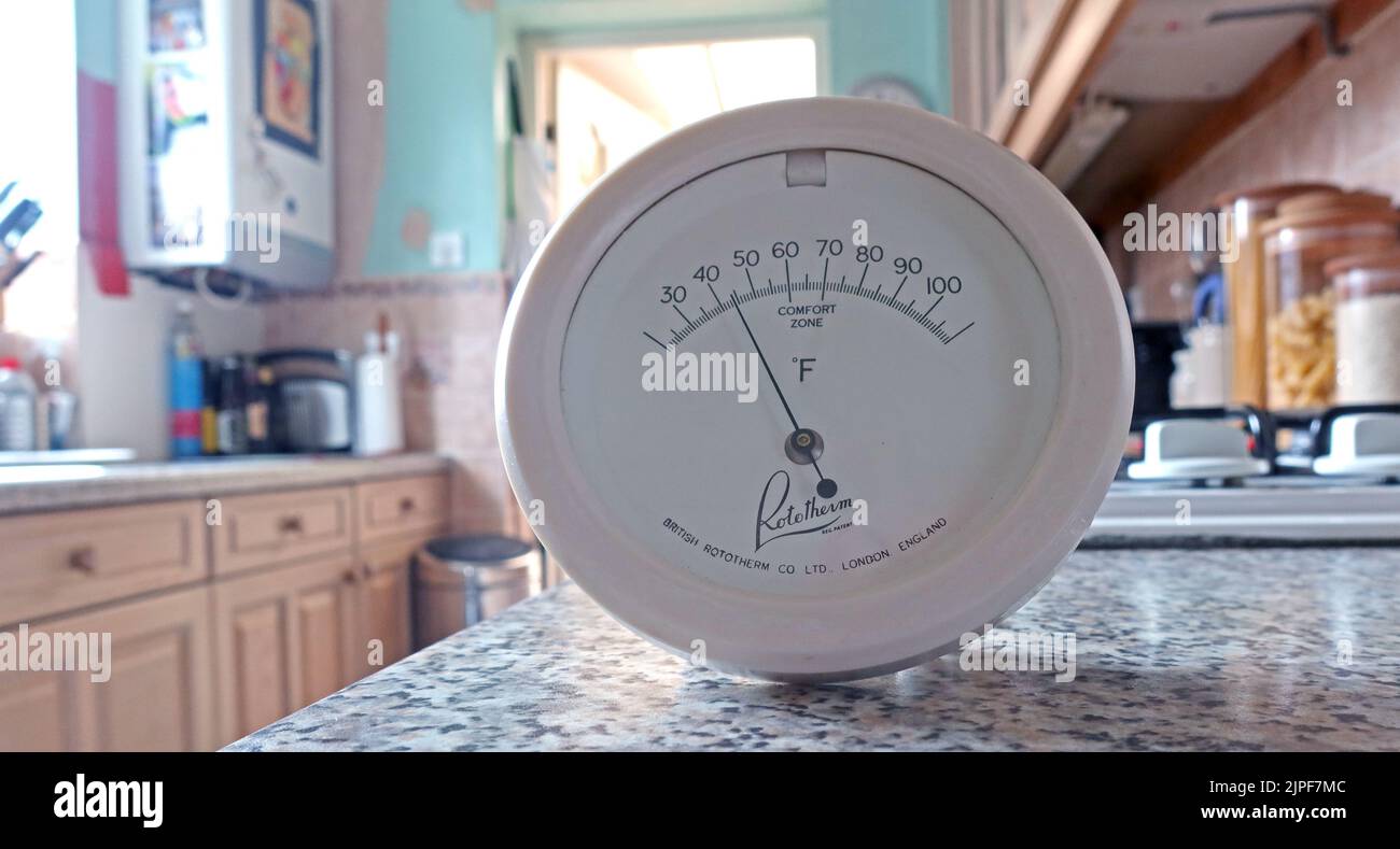 A cold kitchen, with a thermometer showing winter temperature of 45f / 5C, poor have to decide if to heat or eat Stock Photo