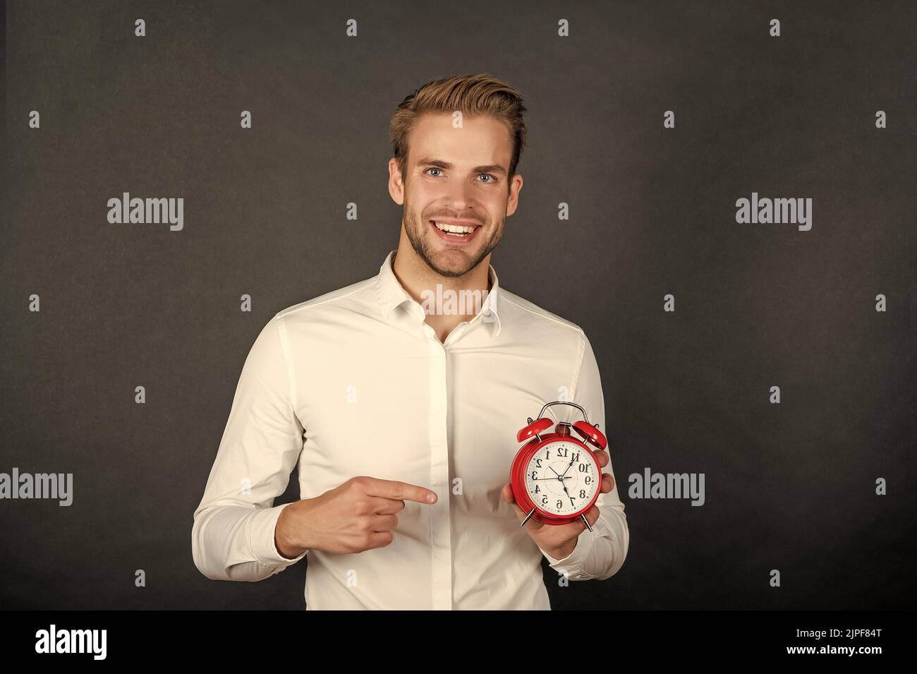 Happy businessman pointing finger at clock. Time management Stock Photo ...