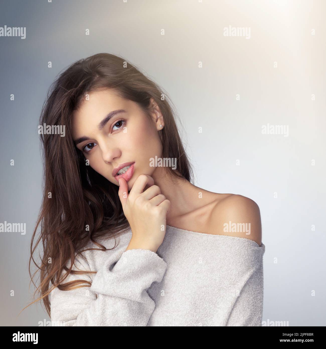 The definition of simplistic beauty. Studio shot of a beautiful young woman posing against a gray background. Stock Photo
