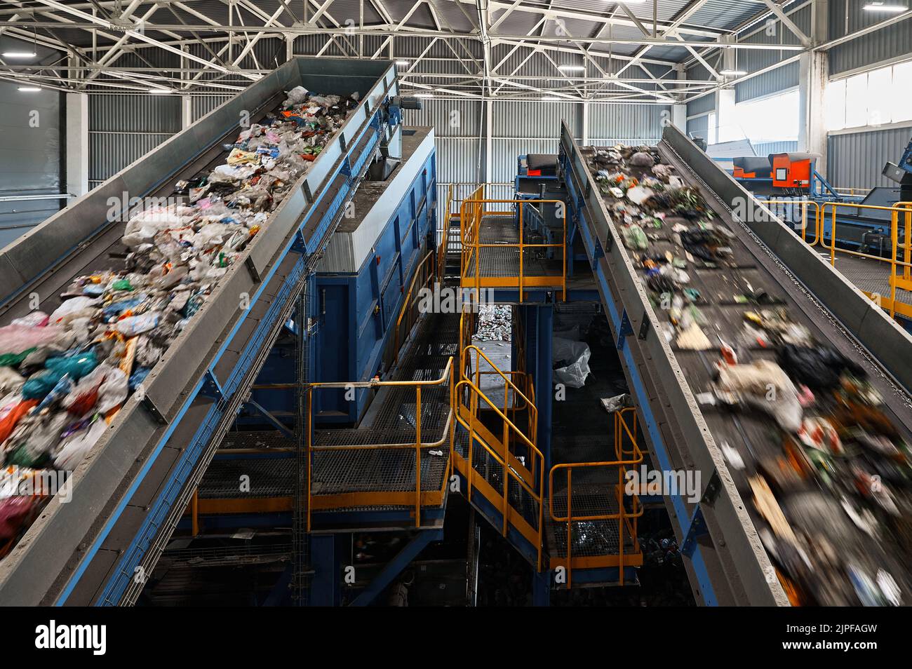 Conveyors carry trash and empty platforms at recycling plant Stock