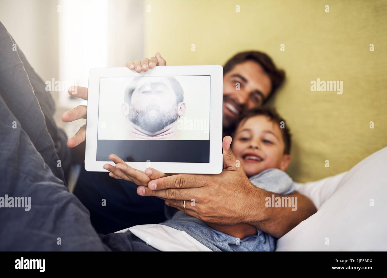 Can you believe this is my face. a young man using a digital tablet ...