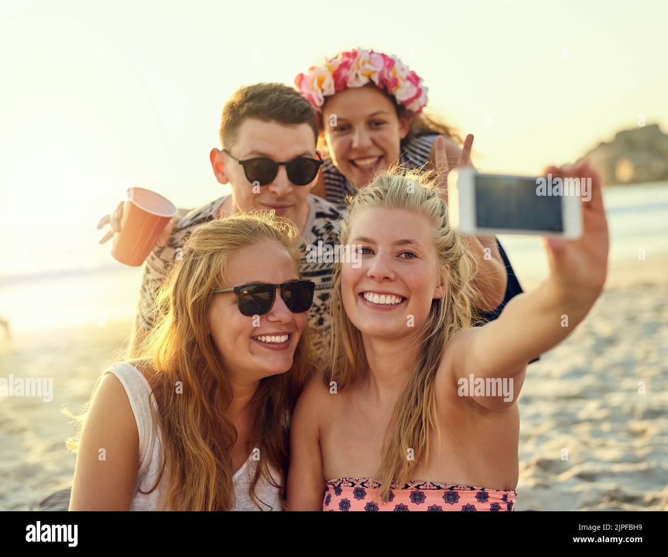 Capturing our moments together. young people hanging out at the beach ...