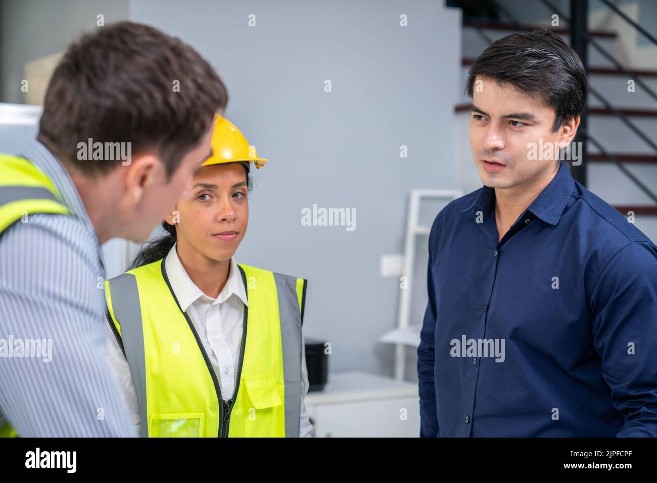 A competent investor investor briefs his engineers on blueprints or construction plans before putting them into action. Concept of investment plans Stock Photo