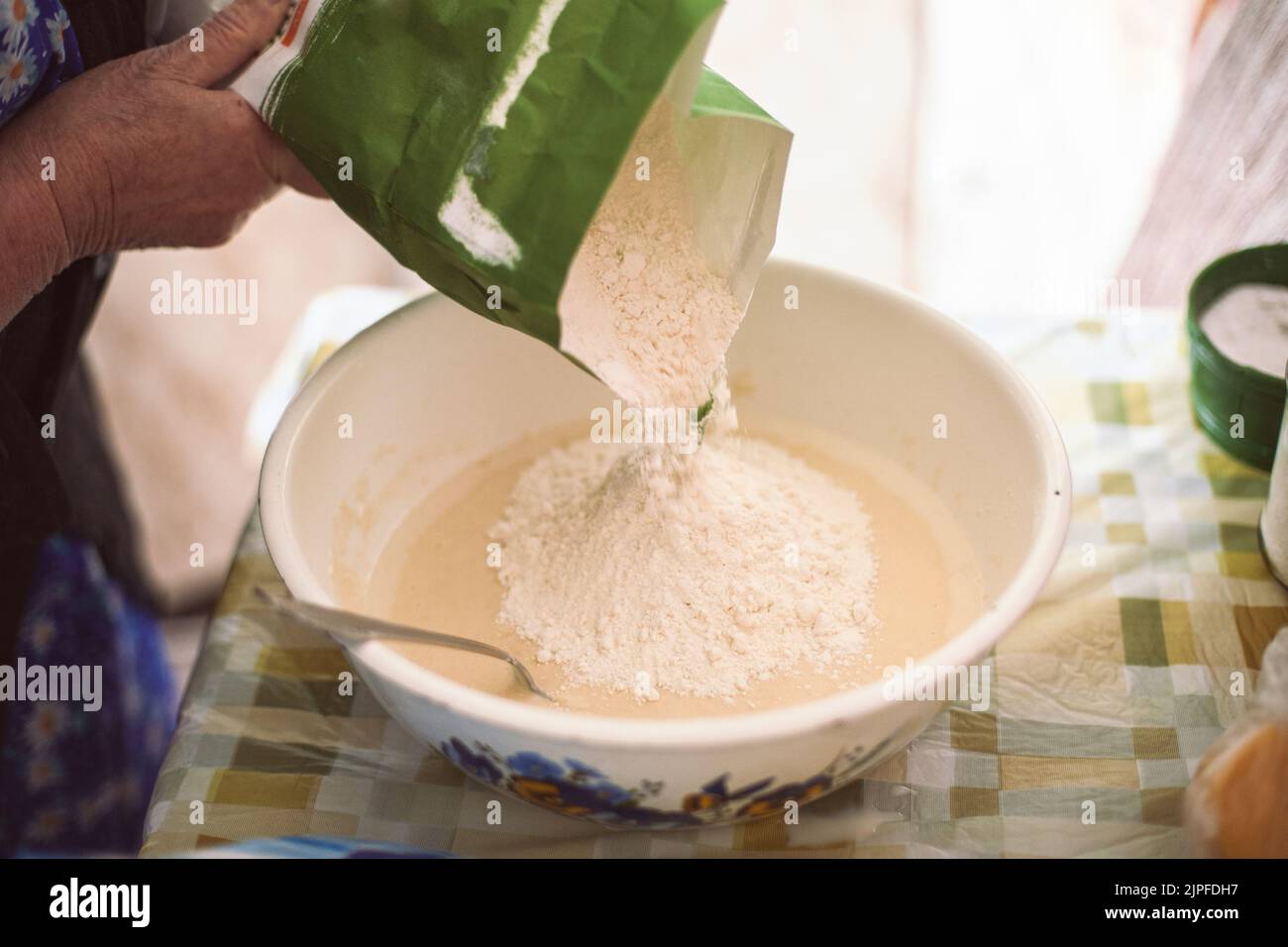 Grandmother pouring flour into pancake batter Stock Photo Alamy