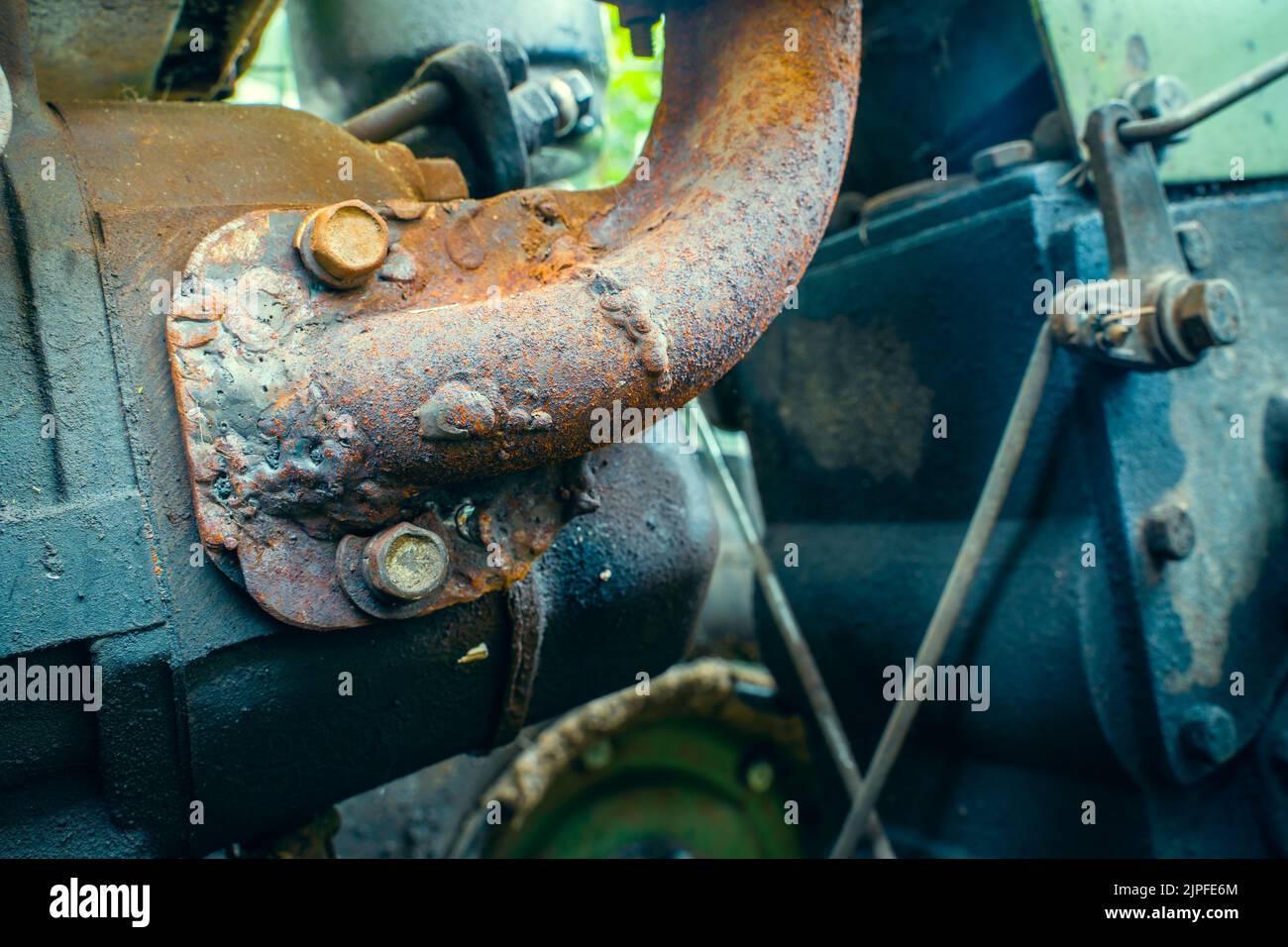 Mounting the exhaust pipe of a walkbehind tractor closeup. Rusty