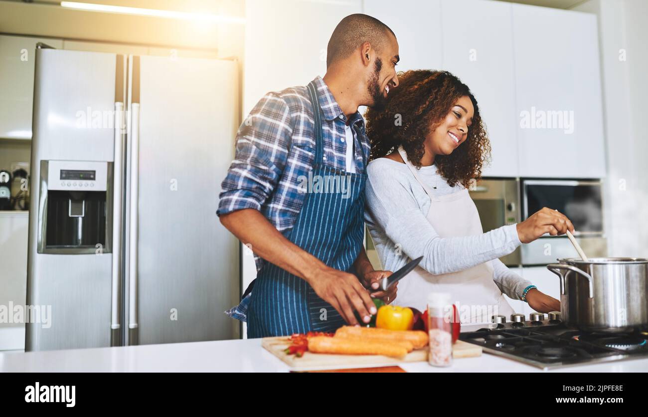 Helping each other cook better. a young couple cooking together at home ...