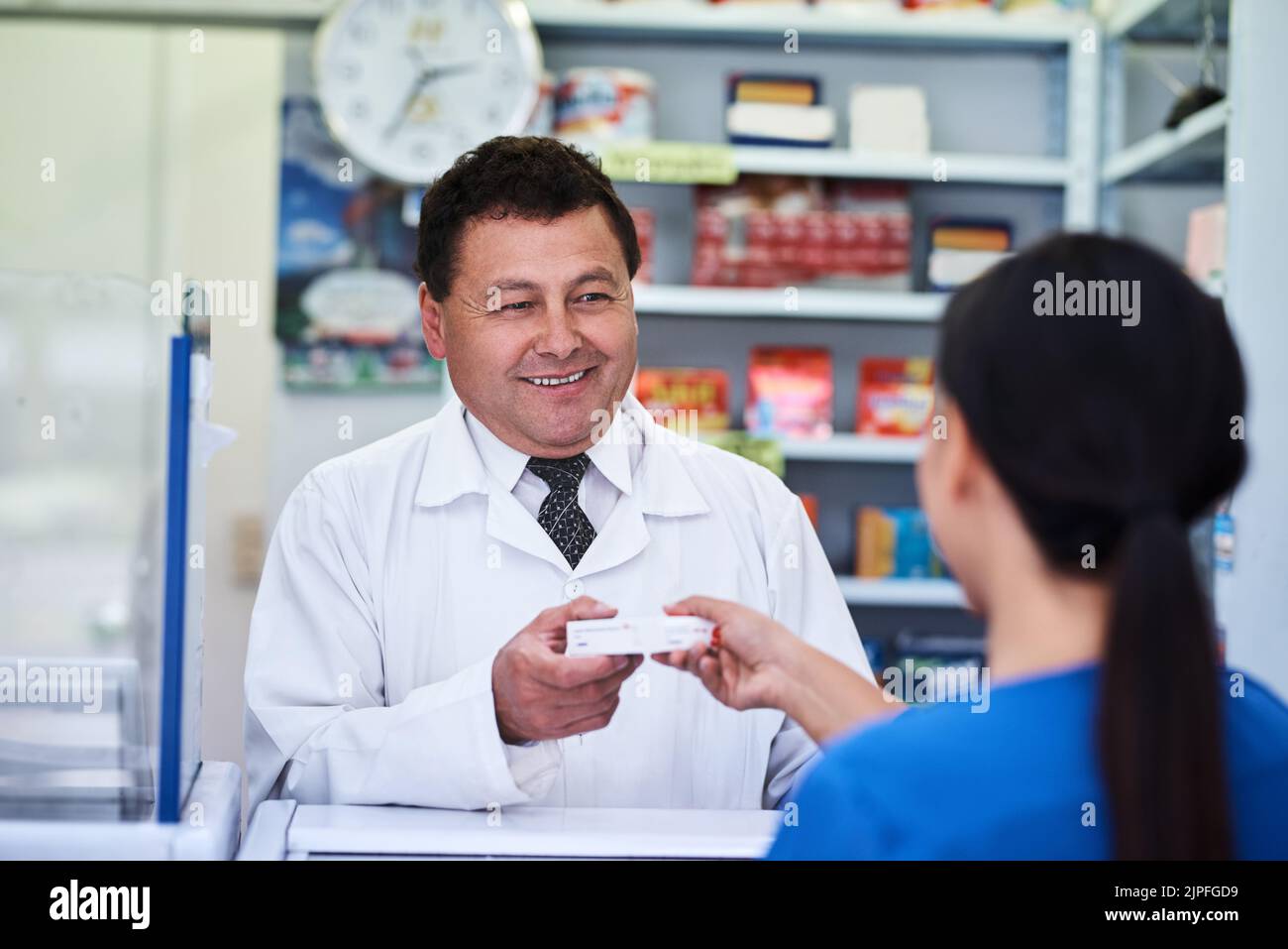 Here is the correct prescription. a male pharmacist helping a female ...