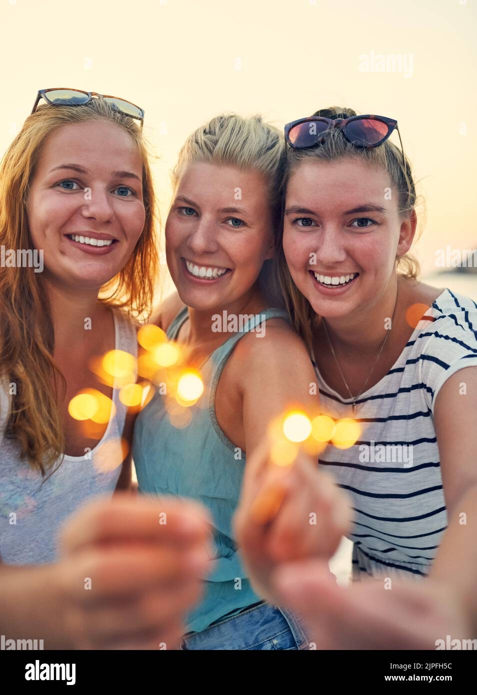 Our friendship is as bright as a sparkler. young female best friends hanging out at the beach. Stock Photo