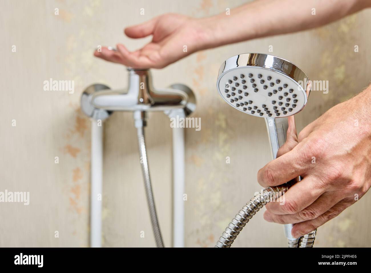 Shower head on flexible hose in bathroom, plumber connected hose to