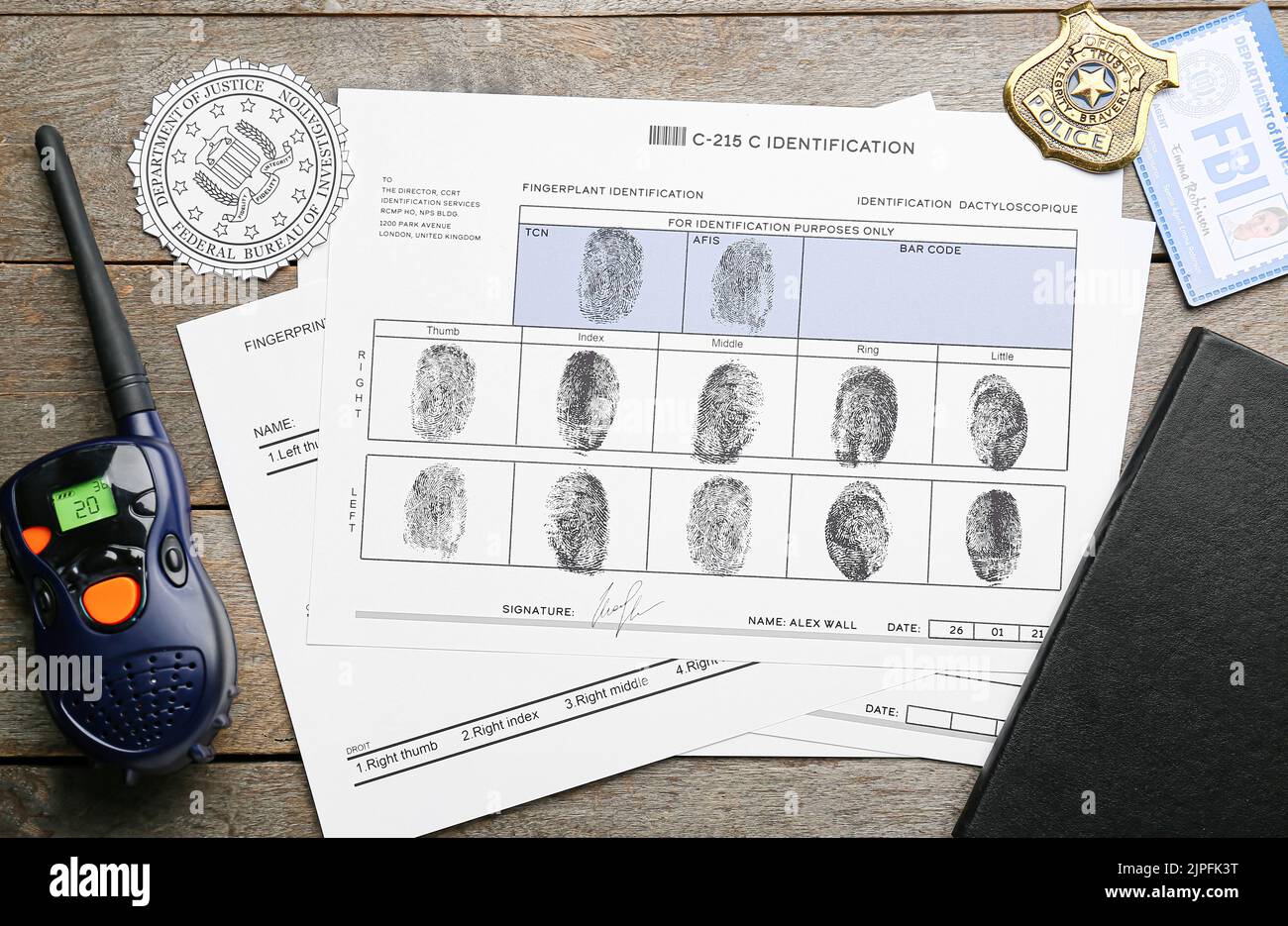Paper sheets with finger prints, FBI seal, badge with portable radio transmitter on wooden background Stock Photo