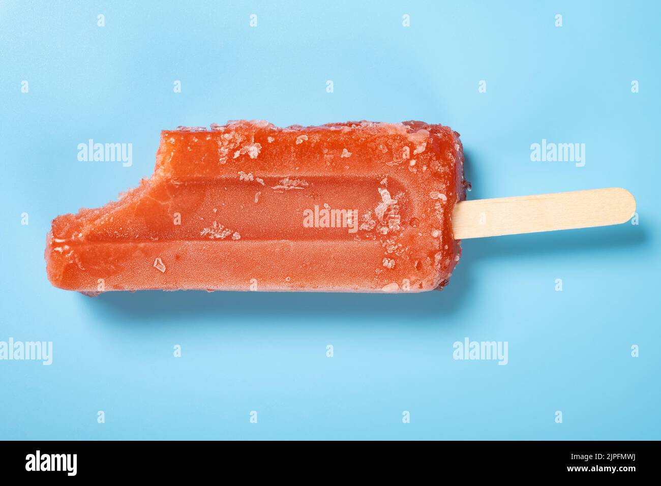 top view fresh red popsicle with a bite on a blue background Stock Photo