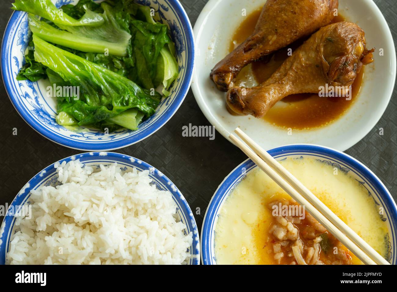 top view fast food of two chicken thighs and steamed eggs and vegetable and bowl of rice horizontal composition Stock Photo