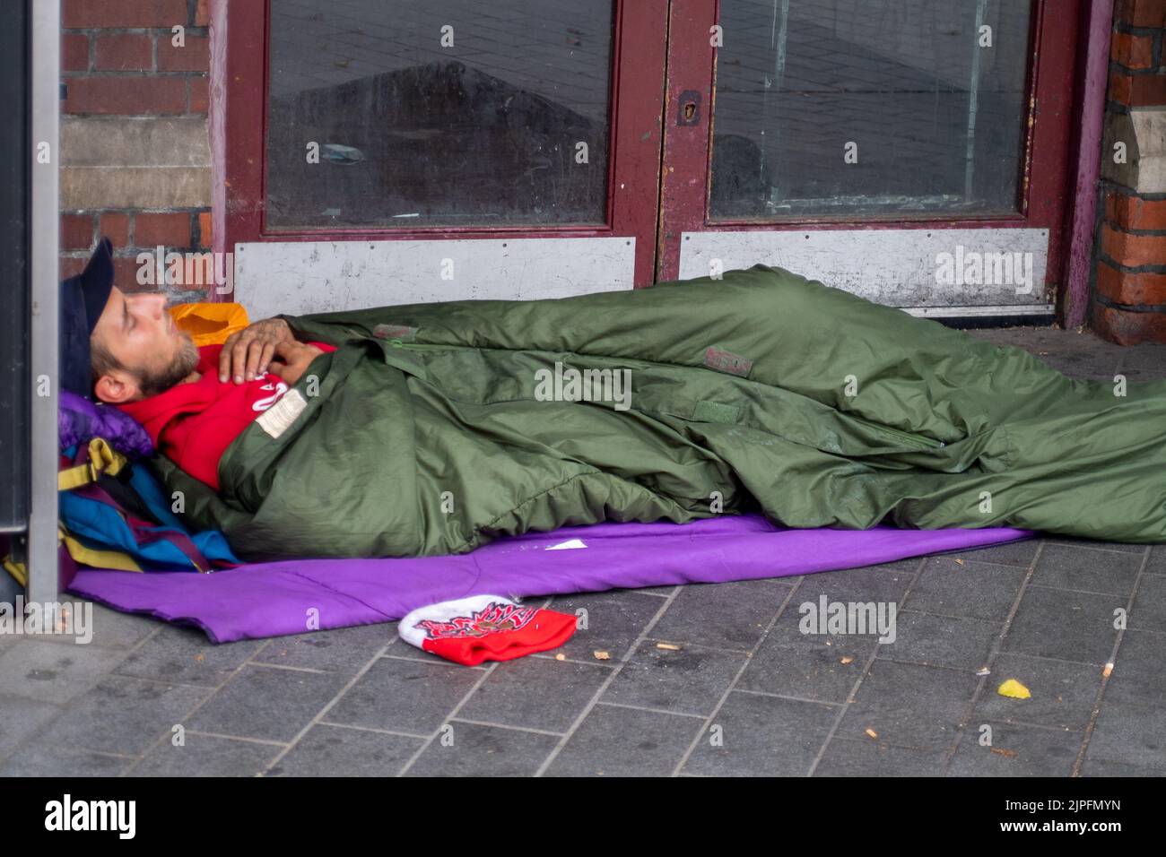 Slough, Berkshire, UK. 17th August, 2022. A homeless man sleeps in the doorway of Slough Railway Station. Credit: Maureen McLean/Alamy Stock Photo