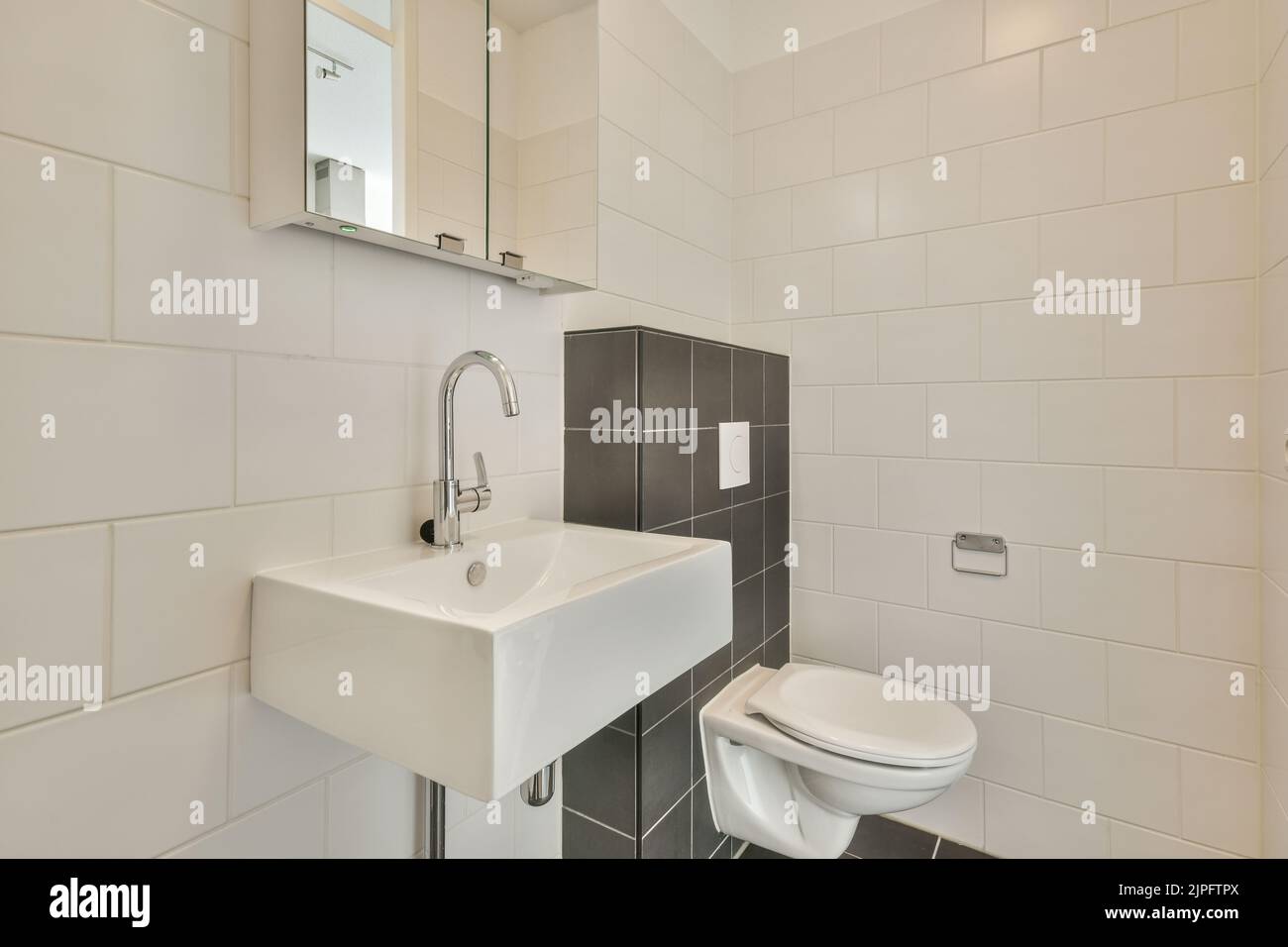 Modern toilet installed on beige wall under button and illuminated