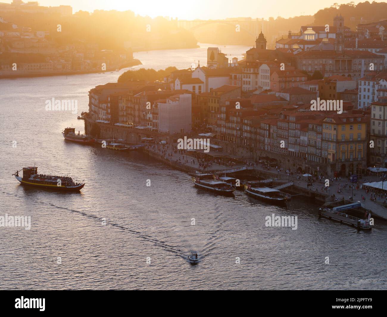 Elevated view of the Ribeira riverfront district and the Douro river in Porto, Portugal. Boat with passengers arrives into the harbour. Stock Photo