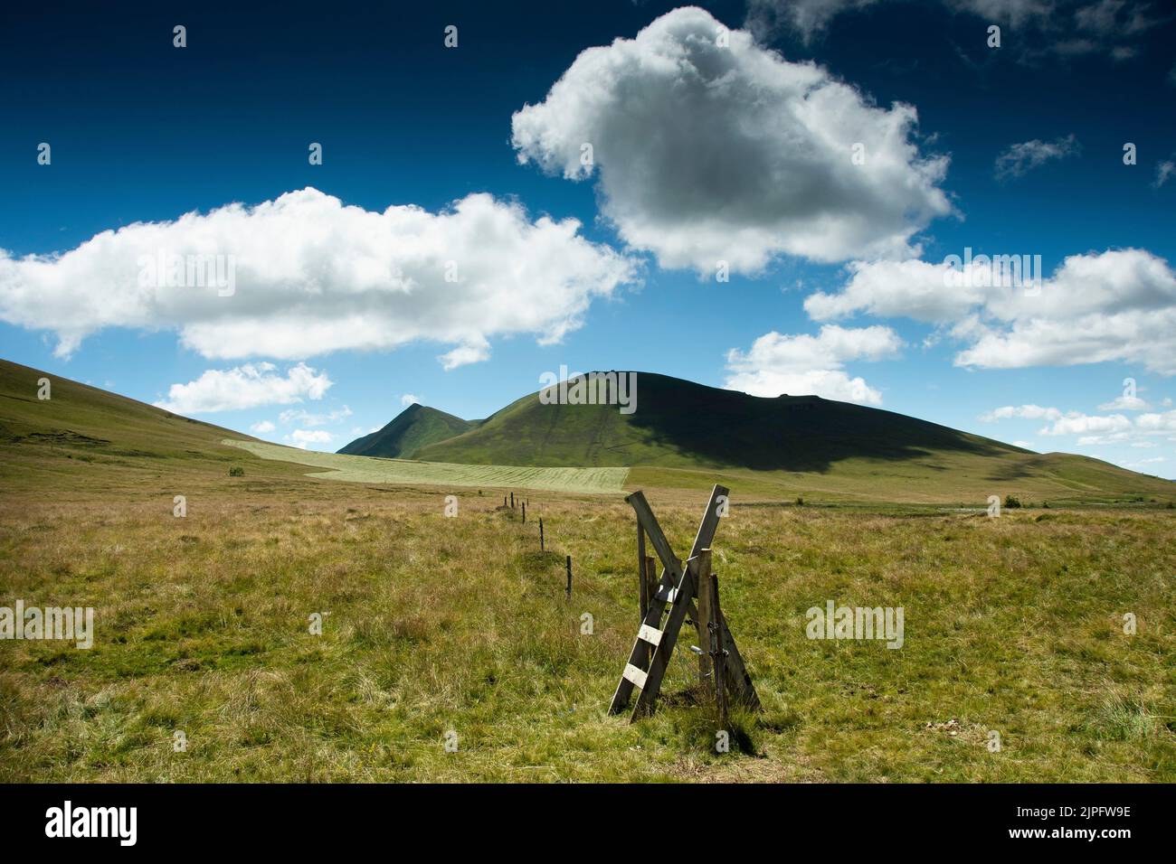 Climbing over stile. Sancy massif , Auvergne Volcanoes Natural Park, Puy de Dome, France Stock Photo