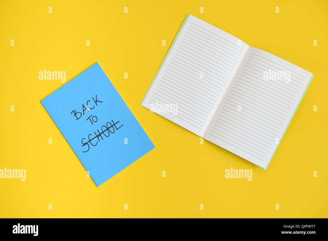 the text back to school written in the cover of a blue notepad, open ...