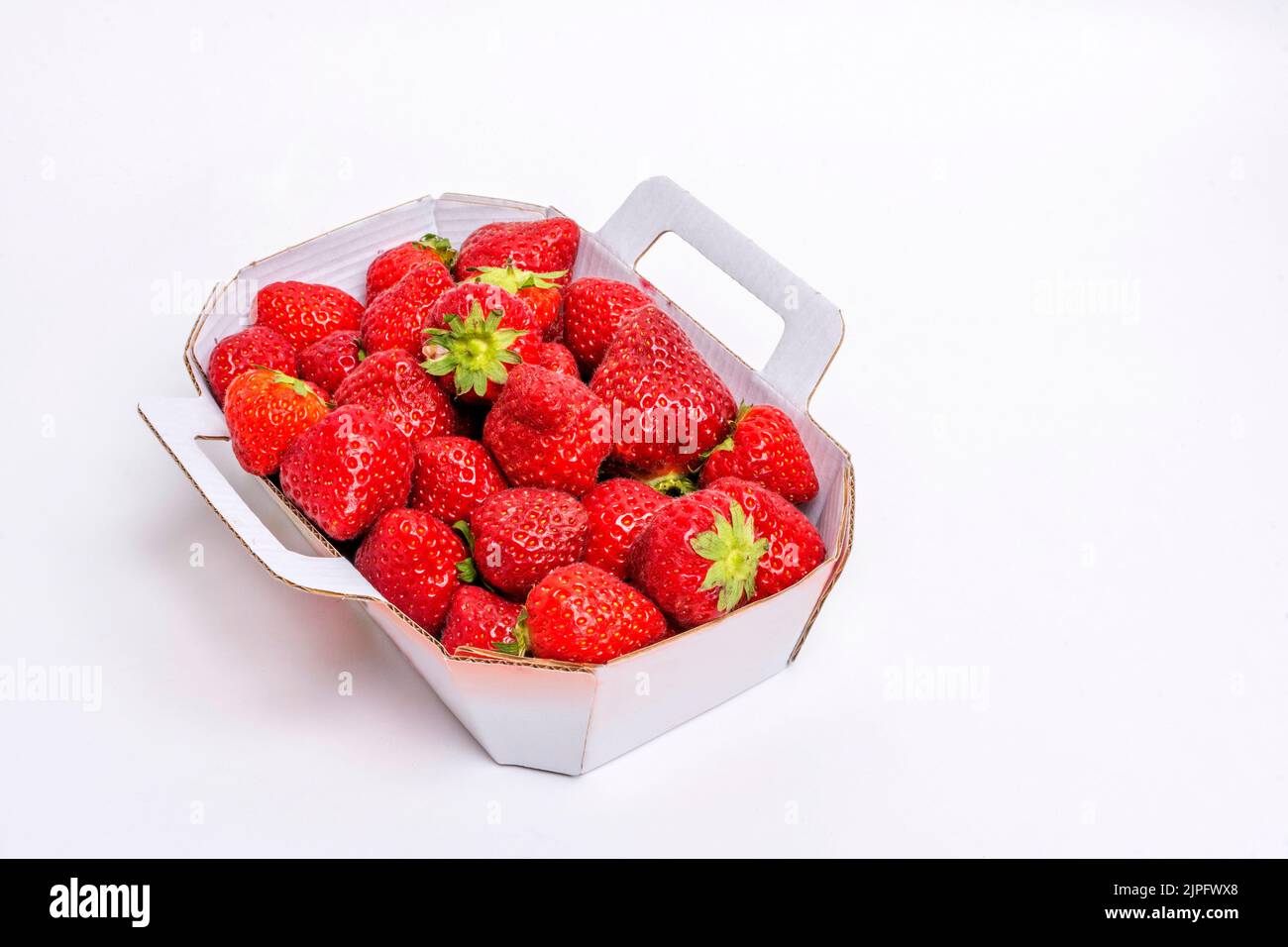 Card box full of red strawberries on a white background Stock Photo