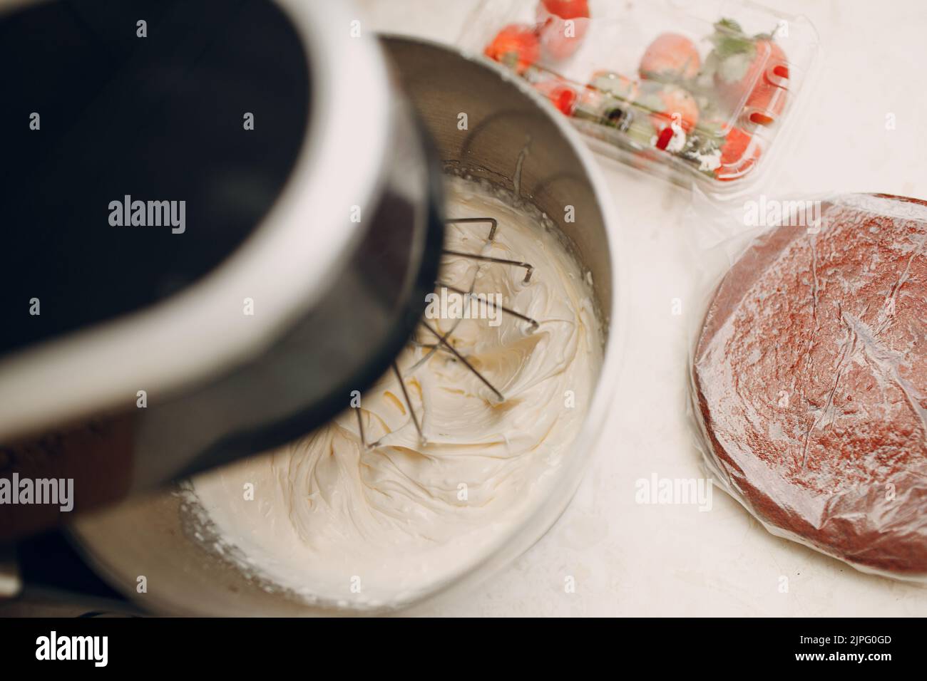 Pastry chef makes cake and making cream on blender. Cooking and decorating dessert Stock Photo