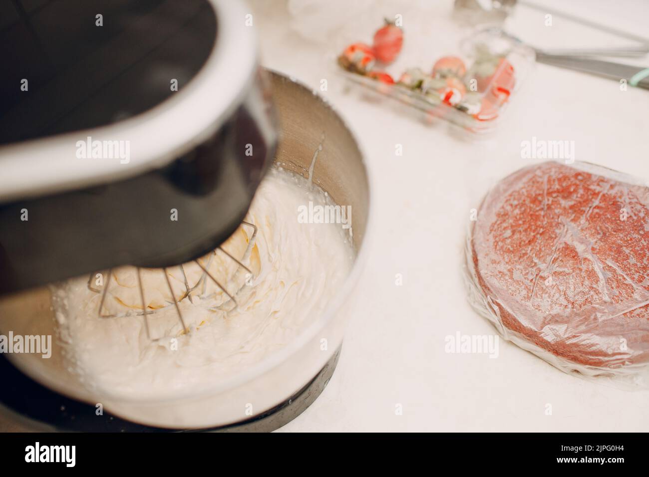 Pastry chef makes cake and making cream on blender. Cooking and decorating dessert Stock Photo