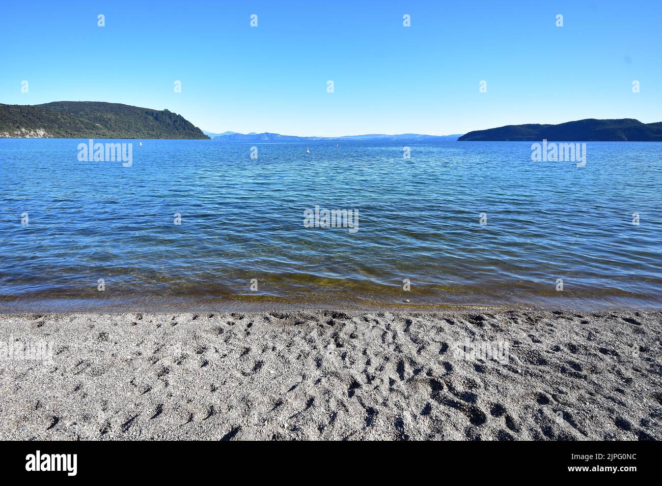 Coarse sandy beach on shore of Lake Taupo in Kinloch. Location: Kinloch New Zealand Stock Photo