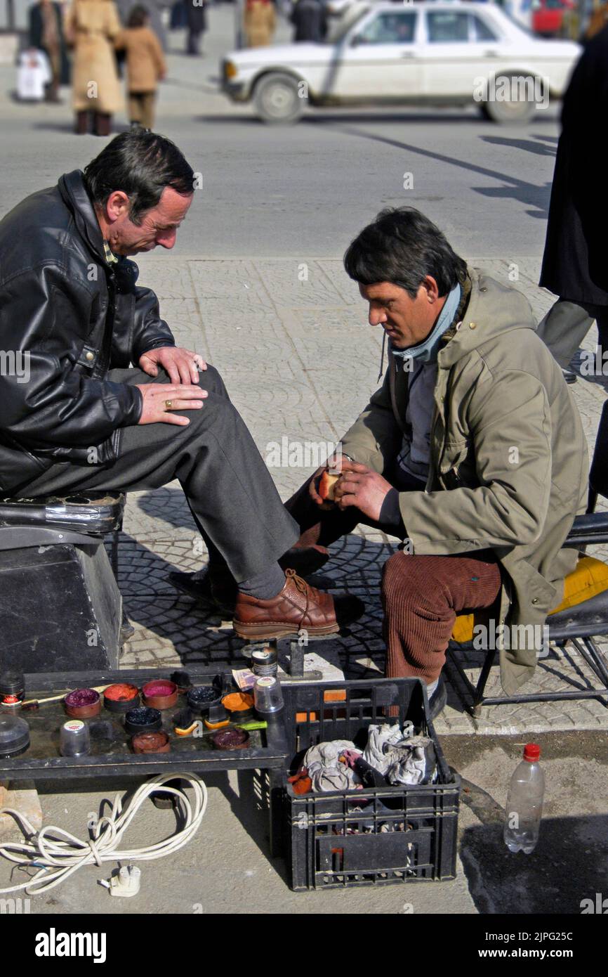Shoeshine on the footpath in central Tirana, Albania Stock Photo