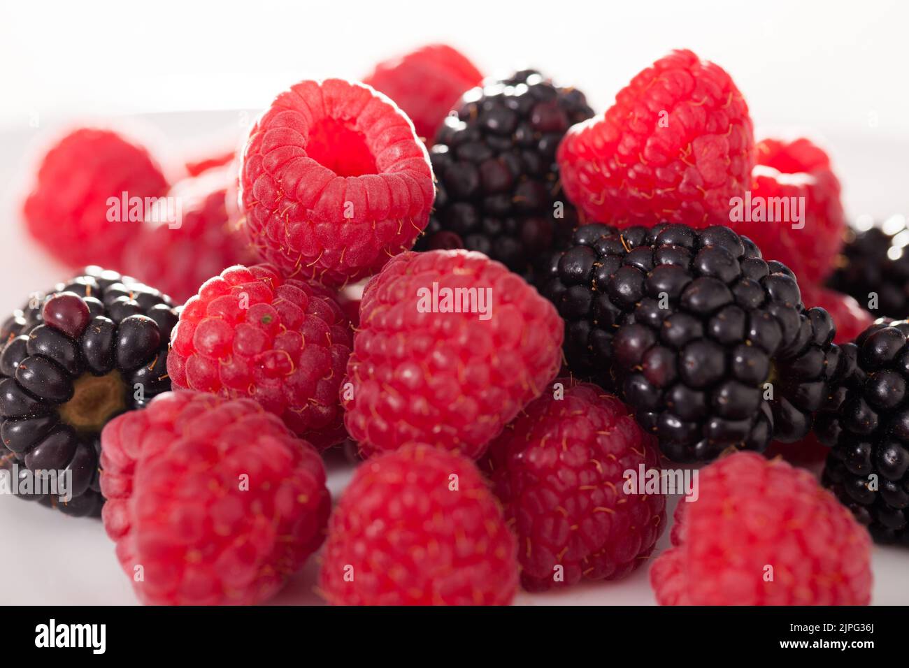 handful of raspberry and blackberry berries on white background Stock ...